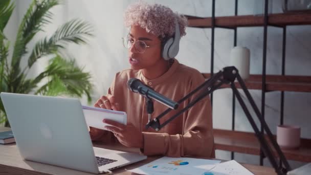 Joven mujer milenaria sentada en el escritorio y lidera su transmisión en vivo en línea — Vídeos de Stock