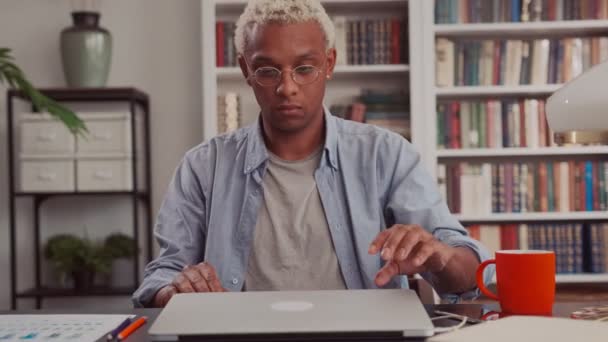 Un jeune homme afro-américain confiant ouvre et commence à utiliser un ordinateur portable au Home Office — Video