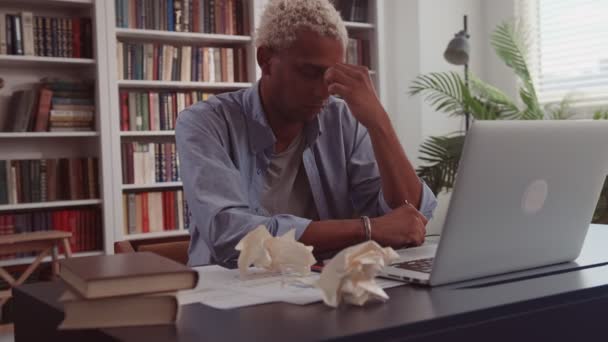 Yorgun Afrikalı bir adam, bilgisayar işinden yorgun düşmüş gözlüğünü çıkartıyor. — Stok video