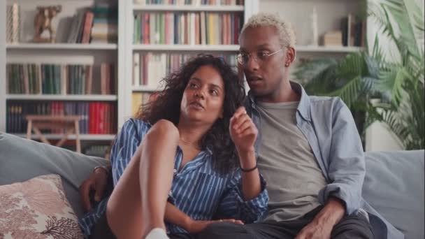 Feliz belo casal interracial abraçando relaxante no sofá no aconchegante apartamento — Vídeo de Stock