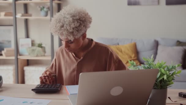 Mujer africana calcula facturas nacionales pagar los pagos de préstamos en línea en el ordenador portátil — Vídeos de Stock