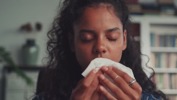 Allergic Indian woman blowing nose in tissue sit on sofa at home office — 图库视频影像