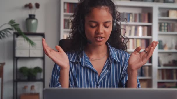 Joven mujer de negocios india con auriculares comunicándose por videollamada. — Vídeos de Stock