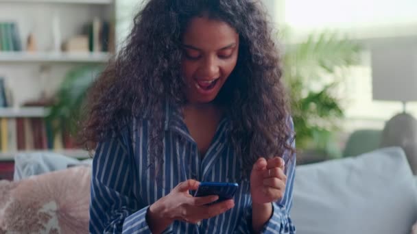 Close up felice donna indiana guardando il telefono mostrando sì gesto sul divano — Video Stock