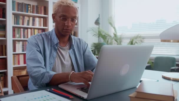 Afroamerykański biznesmen pracujący na laptopie z dokumentami elektronicznymi. — Wideo stockowe