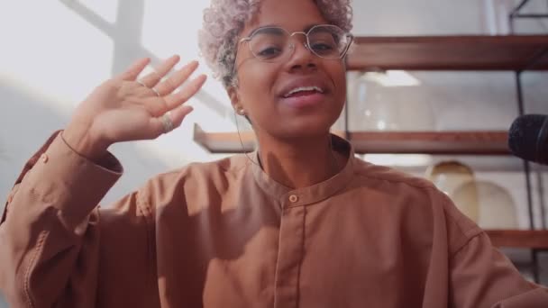 Female blogger waving her hand in front of the camera while recording a video. — Stock Video