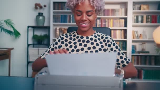 Vídeo engraçado de mulher africana sorridente freneticamente digitando texto na máquina de escrever retro — Vídeo de Stock