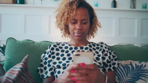 Skoncentrowana Afroamerykanka wysyła SMS-a z telefonu komórkowego. — Wideo stockowe