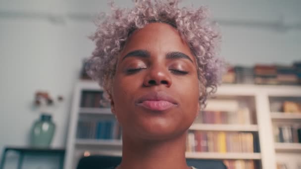 Relaxed african american woman meditating while sitting at work. — Stockvideo