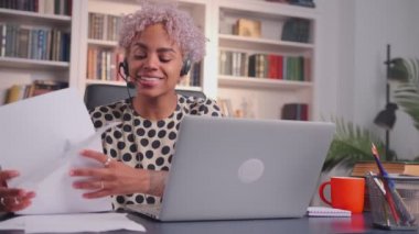 Ofiste oturan iş kadını çevrimiçi hizmetler sunuyor ve müşteriye tavsiyede bulunuyor.