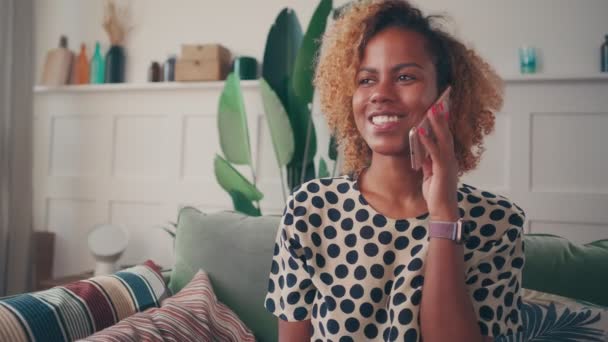 Щаслива африканська американка відчуває задоволення, розмовляючи по телефону.. — стокове відео