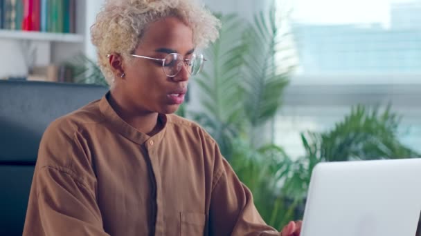 De cerca mujer africana mirando la pantalla del ordenador portátil pensando en la solución del problema. — Vídeos de Stock