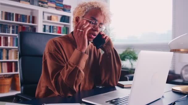 Afrikanerin mit Brille arbeitet im Büro und telefoniert — Stockvideo