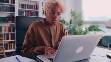Düşünceli Afrikalı kadın laptop ekranına bakıyor, problem çözümü üzerine düşünüyor.
