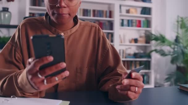 Cerca de la mujer de piel oscura celebrar teléfono inteligente tarjeta de crédito disfrutar de compras en línea — Vídeos de Stock