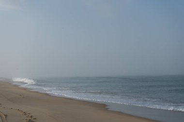 Okyanus dalgaları Vieux-Boucau Sahili 'nde bulutlu bir gökyüzü altında dalgalar Fransa' nın Vieux-Boucau kumsalına yuvarlanarak sakin ve atmosferik bir kıyı sahnesi oluşturur..