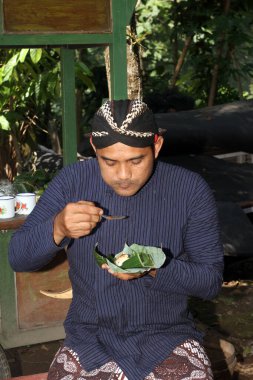 Cavalı adam Sego Kucing yiyor