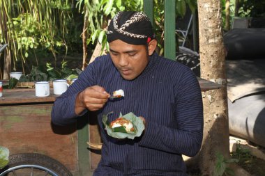 Cavalı adam Sego Kucing yiyor