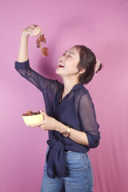 Asyalı kadın bir kase hurma getir.