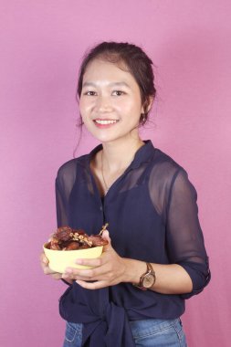 Asyalı kadın bir kase hurma getir.