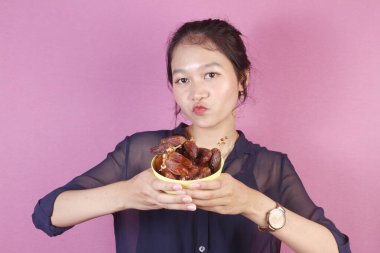 Asyalı kadın bir kase hurma getir.