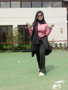 Genç Asyalı kadın dışarıda spor yapıyor.