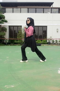 Genç Asyalı kadın dışarıda spor yapıyor.