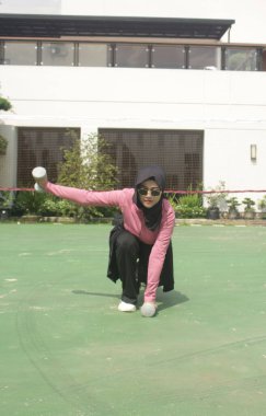 Parkta tenis oynayan Asyalı kız.