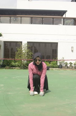 Spor giysileri giyen Asyalı bir kadın.