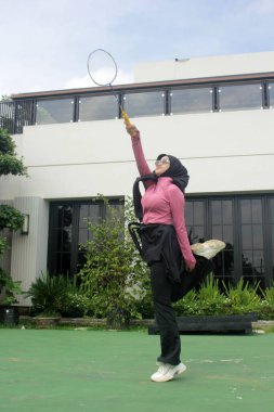 Parkta badminton oynayan Asyalı kadın