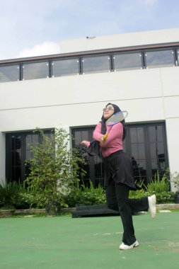 Parkta badminton oynayan Asyalı kadın