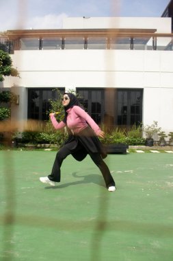 Parkta badminton oynayan Asyalı kadın