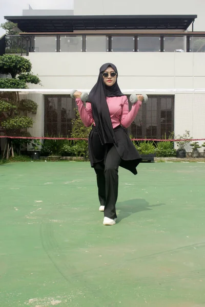 Asyalı Müslüman kadın dışarıda spor yapıyor.