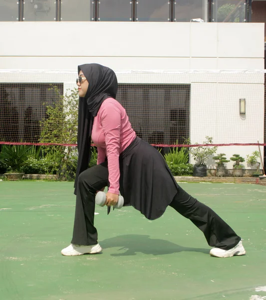 tesettürlü kadın dışarıda egzersiz yapıyor.