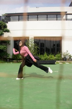 Parkta badminton oynayan Asyalı kadın