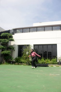 Parkta badminton oynayan Asyalı kadın