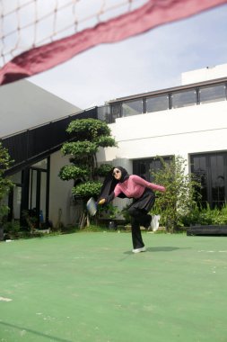 Parkta badminton oynayan Asyalı kadın.