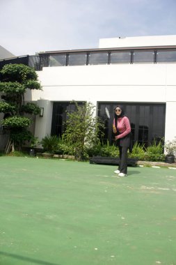 Parkta badminton oynayan Asyalı kadın.