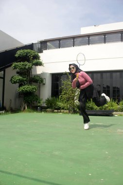 Parkta badminton oynayan Asyalı kadın