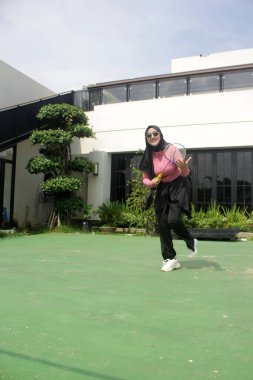 Parkta badminton oynayan Asyalı kadın.