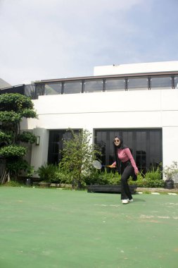 Parkta badminton oynayan Asyalı kadın.