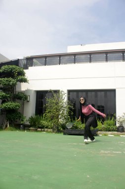 Parkta badminton oynayan Asyalı kadın.