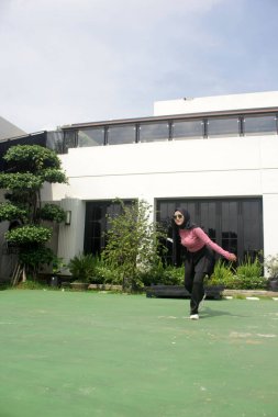 Parkta badminton oynayan Asyalı kadın.