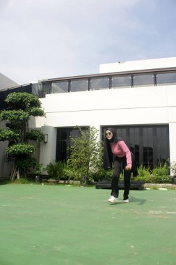 Parkta badminton oynayan Asyalı kadın.