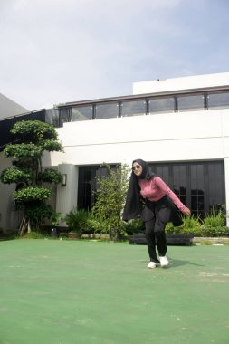 Parkta badminton oynayan Asyalı kadın.