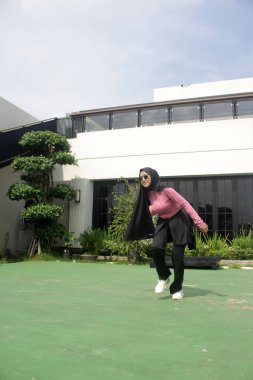 Parkta badminton oynayan Asyalı kadın.