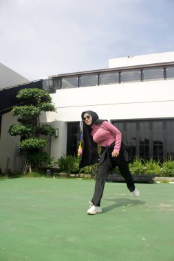 Parkta badminton oynayan Asyalı kadın.