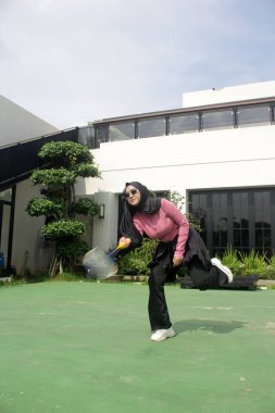 Parkta badminton oynayan Asyalı kadın.