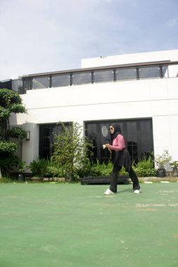 Parkta badminton oynayan Asyalı kadın.