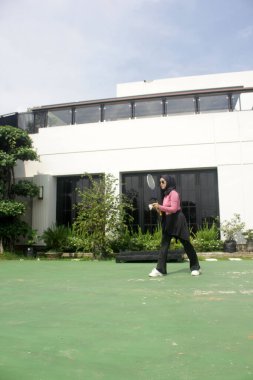 Parkta badminton oynayan Asyalı kadın.